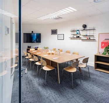 Newton Offices meeting room with a large wooden table and screen
